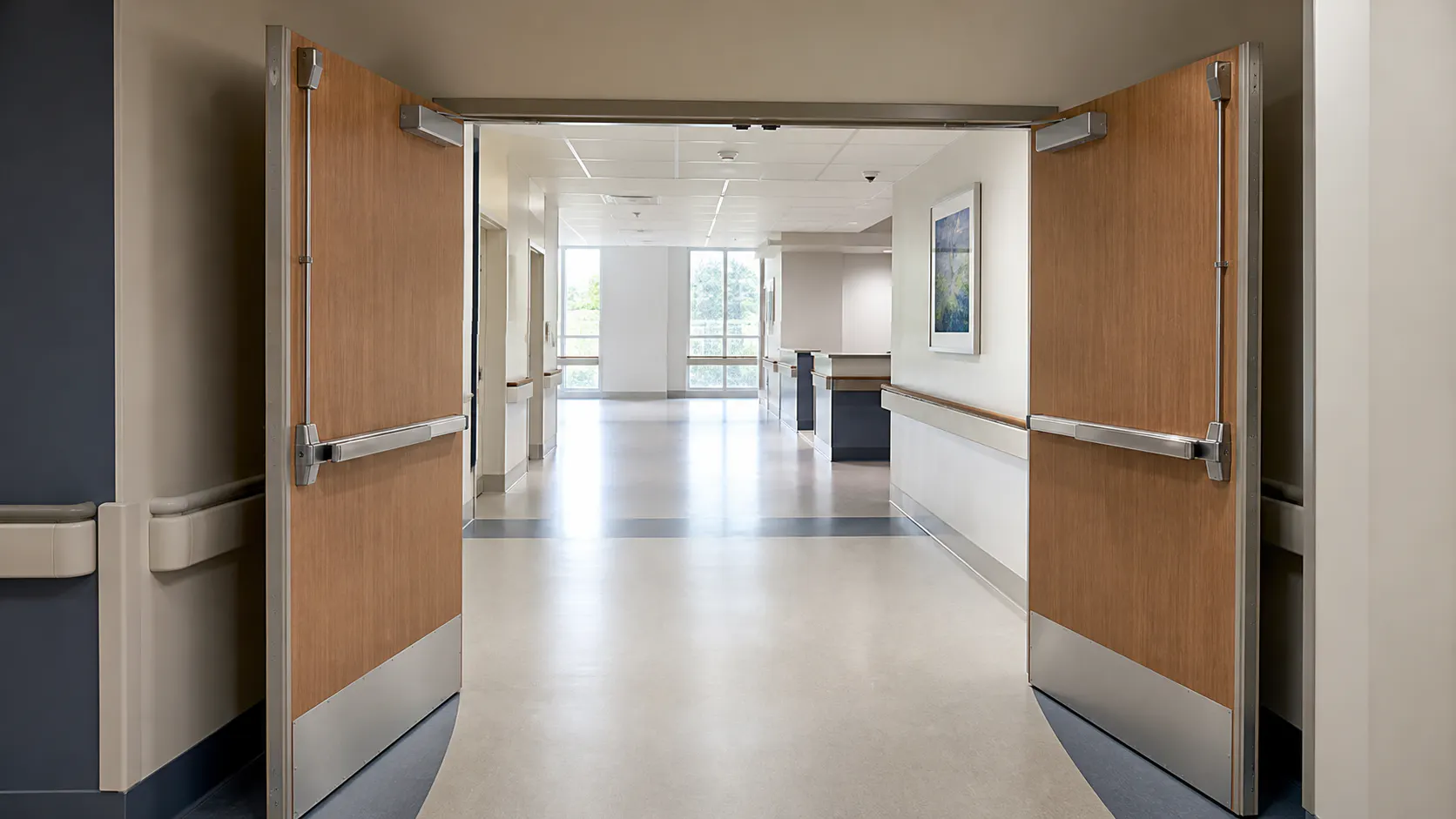 Opposing-swing double-egress door assembly in a clear hospital corridor